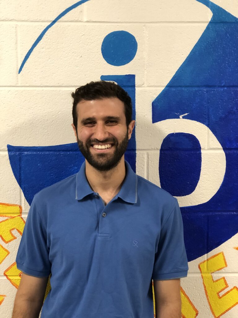 Omar Darea standing by the IB wall