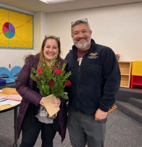 Ms. Krisko standing with Principal Ramirez holding flowers.